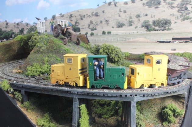 Ruston’s 4, 5 (in the new experiential green livery) and 6 slowly haul their load of crushed ballast over a wooden trestle bridge.